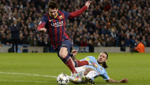 Lionel Messi grätscht im Fußballspiel gegen einen Gegenspieler.