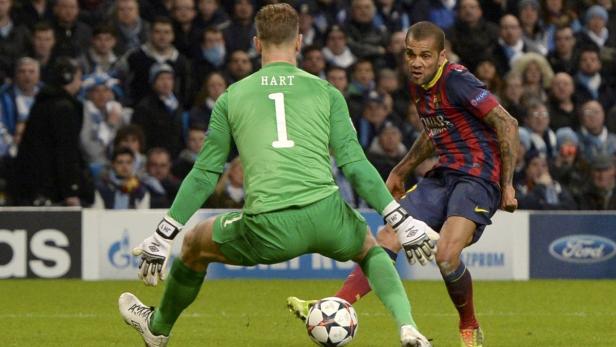 Ein Fußballspieler von Barcelona schießt auf das Tor, während der Torwart von Manchester City sich bereit macht, den Ball abzuwehren.