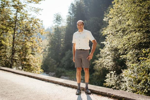 Ein Mann steht auf einer Brücke in einer grünen Landschaft.