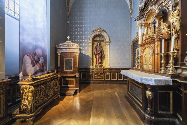 Innenansicht einer reich verzierten Kapelle mit einer Statue und einem Bild von Papst Johannes Paul II..