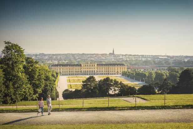 Ein Paar spaziert mit Blick auf Schloss Schönbrunn in Wien.