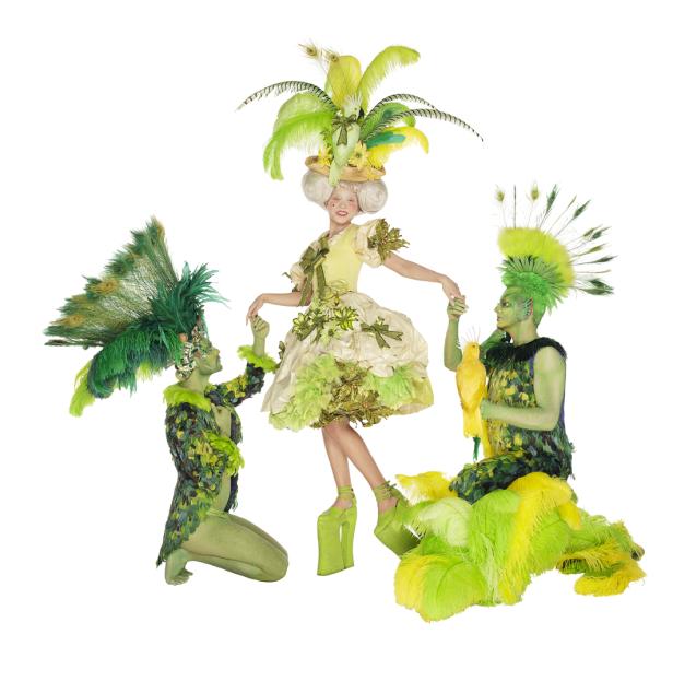 Drei Personen in fantasievollen, grünen Kostümen posieren vor einem weißen Hintergrund.