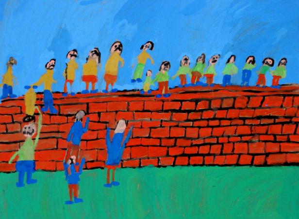 Eine Gruppe von Menschen steht auf und vor einer roten Backsteinmauer.