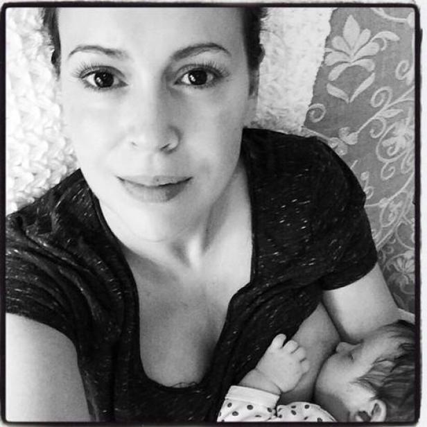 Eine Frau stillt ihr Baby in einem Schwarzweißfoto.