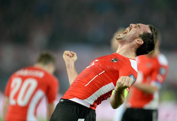 Ein österreichischer Fußballspieler jubelt mit geballten Fäusten und geöffnetem Mund.