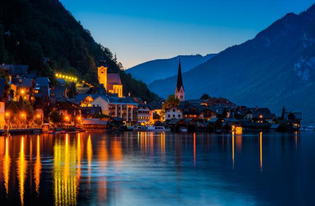 Hallstatt in Österreich bei Nacht mit beleuchteten Häusern am See.