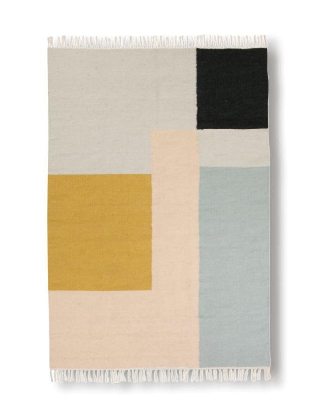 Ein Teppich mit geometrischen Formen in Gelb, Schwarz, Beige und Blaugrau.