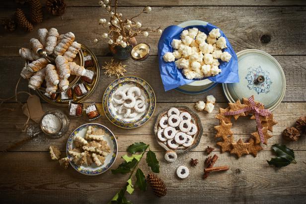 Verschiedene Weihnachtsplätzchen sind auf einem Holztisch angerichtet.