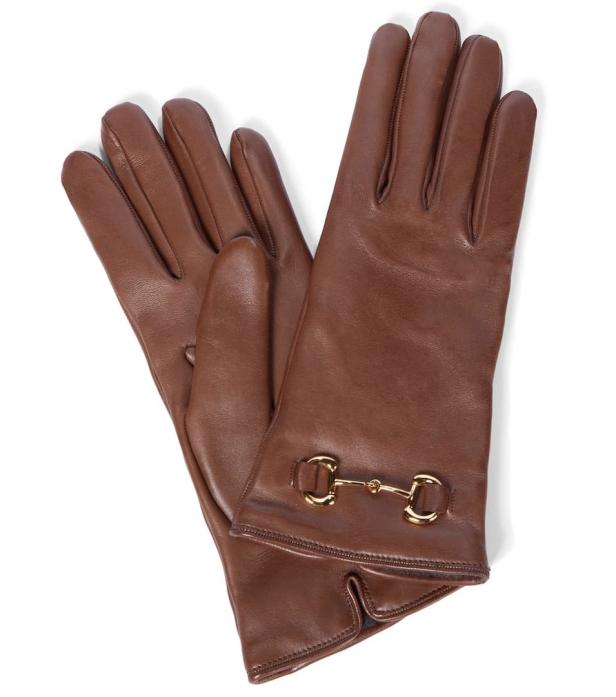 Ein Paar braune Lederhandschuhe mit goldenen Zierbeschlägen.