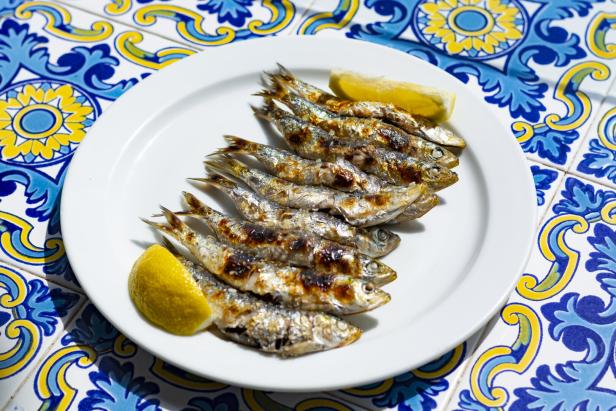 Espeto, Malaga style fish on stick barbecue prepared on olive tree firewoods