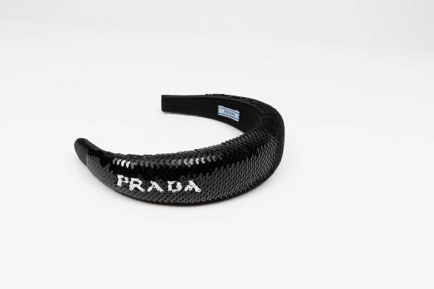 Ein schwarzes Prada-Stirnband mit Pailletten liegt auf einem weißen Hintergrund.