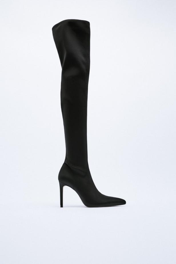Ein schwarzer, hochhackiger Overknee-Stiefel vor einem weißen Hintergrund.