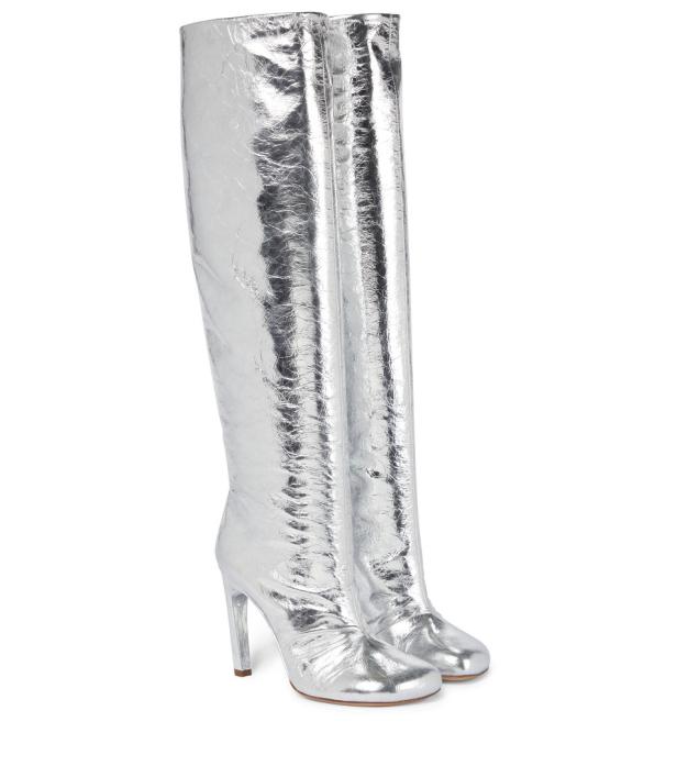 Ein Paar silberne Overknee-Stiefel mit Absatz stehen auf einem weißen Hintergrund.