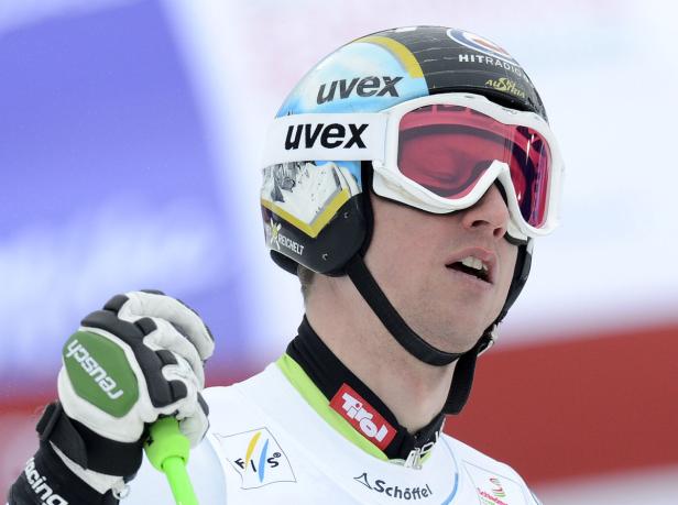 Ein Skirennläufer mit Helm und Skibrille blickt konzentriert zur Seite.