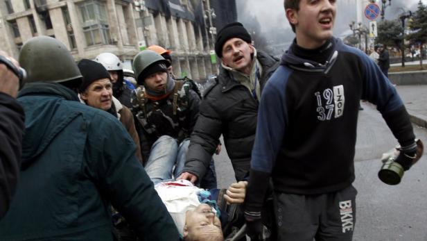 Sanitäter transportieren einen verletzten Mann auf einer Trage.