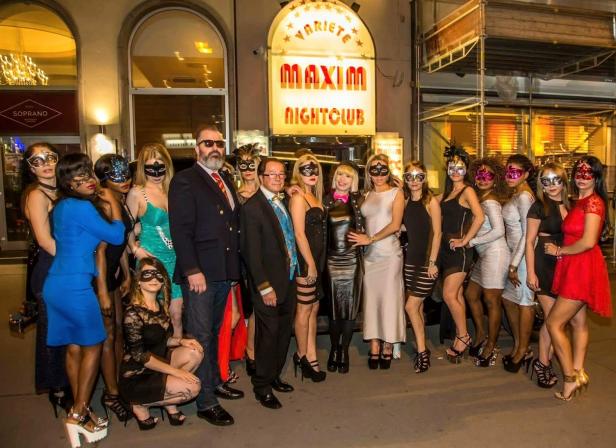 Eine Gruppe von Menschen mit Masken posiert vor dem „Maxim Nightclub“.