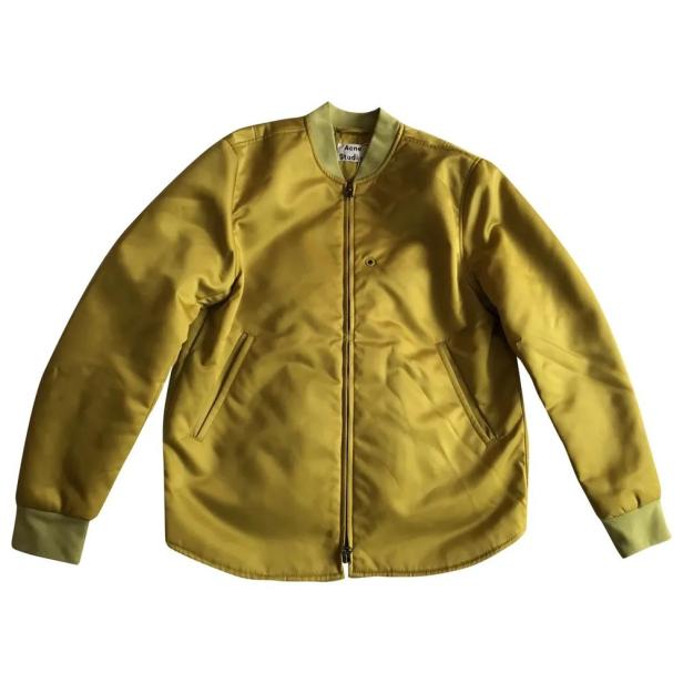 Eine goldgelbe Bomberjacke von Acne Studios vor einem weißen Hintergrund.