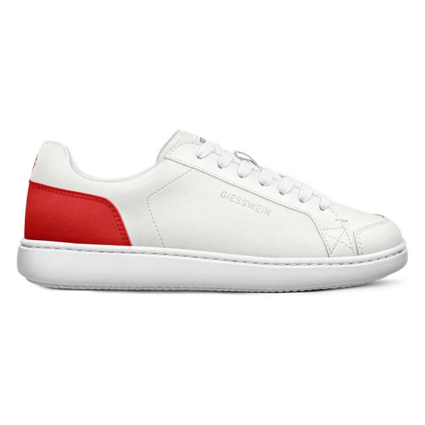 Ein weißer Giesswein-Sneaker mit rotem Detail an der Ferse.