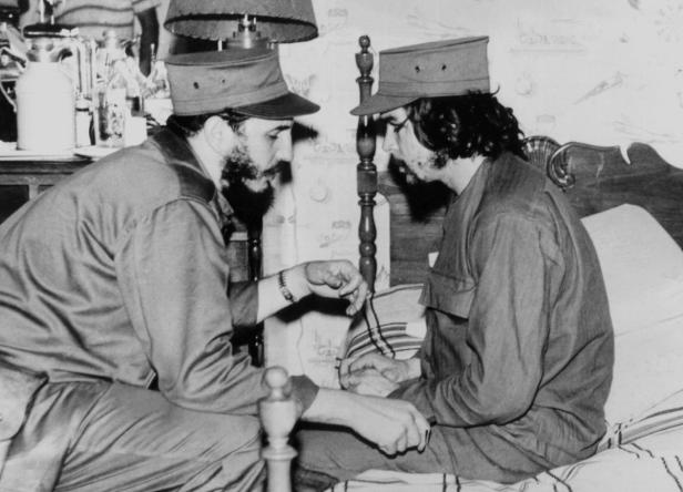 Fidel Castro und Che Guevara sitzen in einem Raum und unterhalten sich.