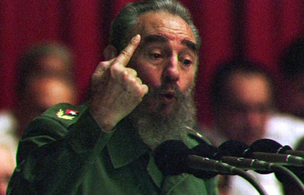 Fidel Castro gestikuliert während einer Rede vor Mikrofonen.