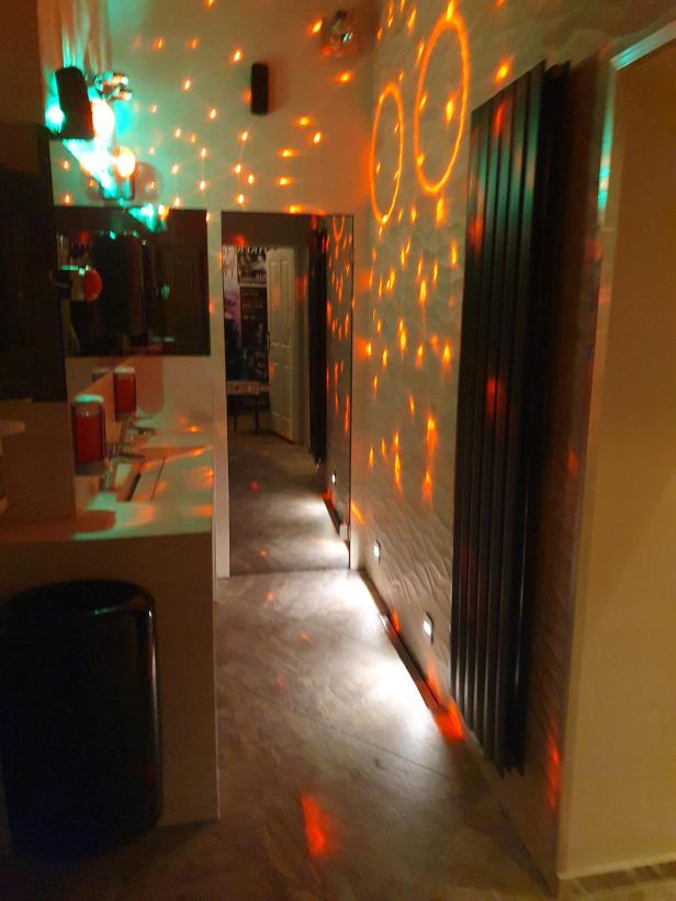Ein Flur ist mit bunten Lichtern beleuchtet, die von einer Discokugel reflektiert werden.