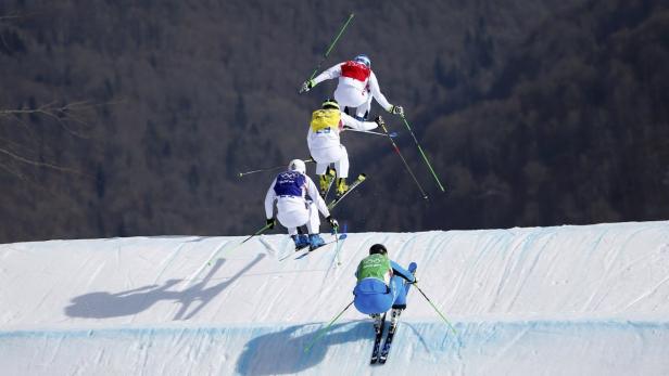 Mehrere Skispringer absolvieren einen Sprung über eine schneebedeckte Rampe.