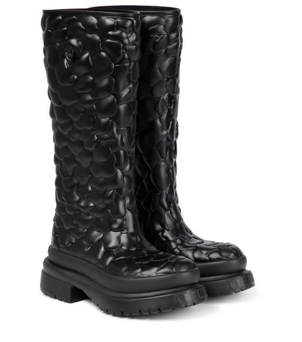 Ein Paar schwarze, kniehohe Gummistiefel mit einem floralen Muster.