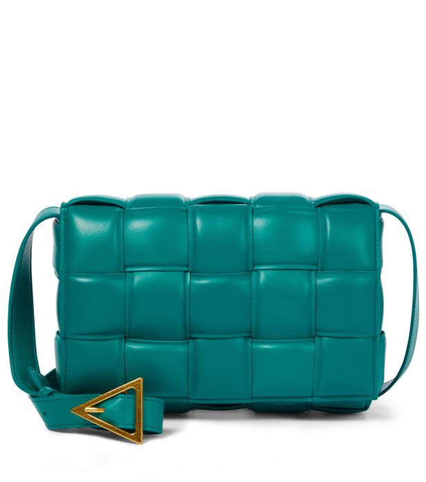 Eine türkisfarbene, geflochtene Ledertasche mit goldenem Schnallenverschluss.