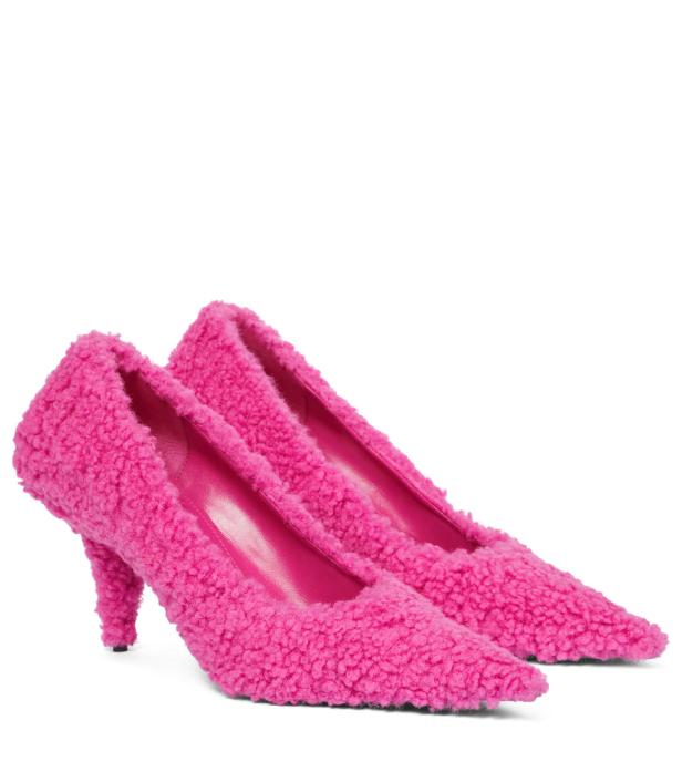 Ein Paar pinkfarbene, flauschige High Heels stehen auf einem weißen Hintergrund.