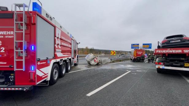 Ein Unfall auf der Autobahn mit Feuerwehrfahrzeugen und einem beschädigten Auto.