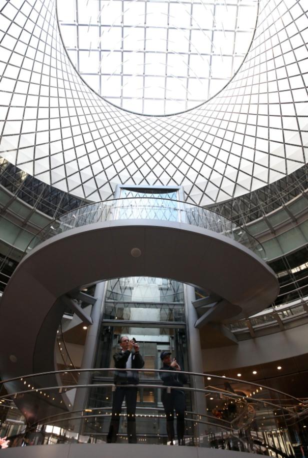 Zwei Personen stehen auf einer Galerie und fotografieren die beeindruckende Glaskuppel.