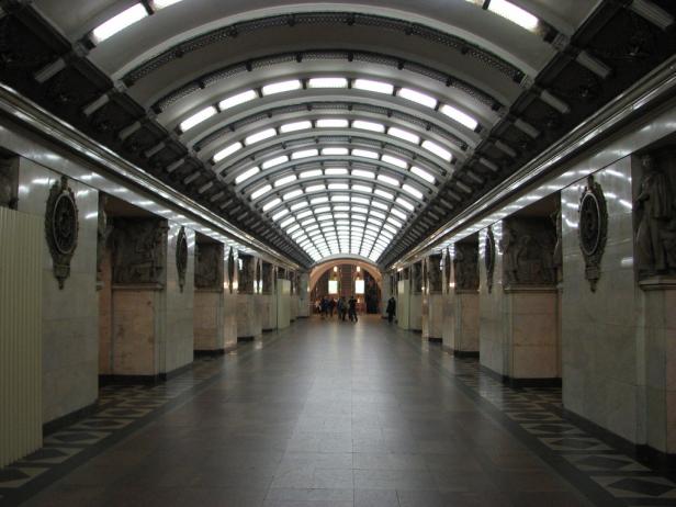 Ein Gang in einer U-Bahn-Station mit Marmorsäulen und gewölbter Decke.