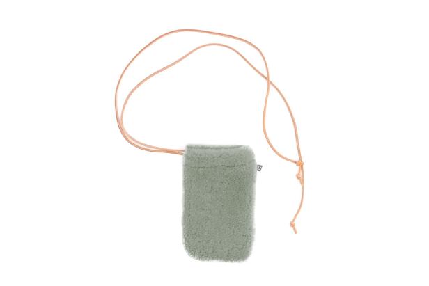 Eine kleine, hellgrüne Tasche aus Teddyfell mit einem dünnen, hellbraunen Trageriemen.