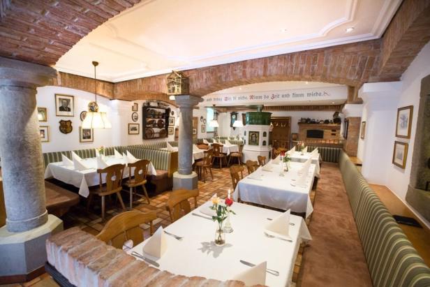 Ein traditionell eingerichtetes Restaurant mit gedeckten Tischen und gemauerter Dekoration.