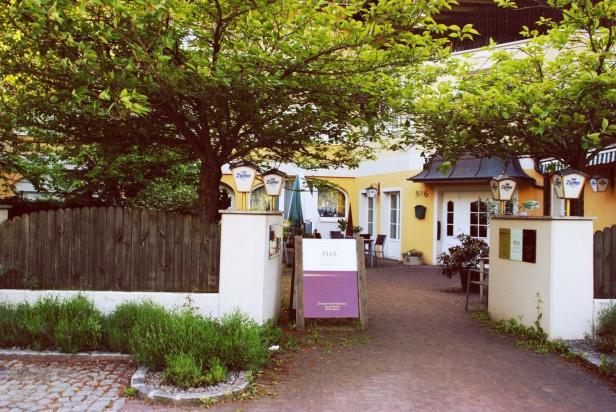 Der Eingangsbereich eines gelben Hauses mit der Nummer 6 und Zipfer-Bierwerbung.