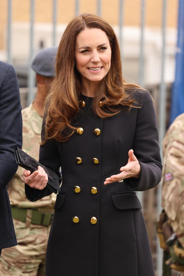 Catherine, Prinzessin von Wales, in einem schwarzen Mantel mit goldenen Knöpfen.