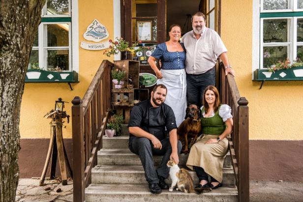 Mitarbeiter und Familie des Wirtshauses „Waldviertler Karpfen“ sitzen auf der Treppe.