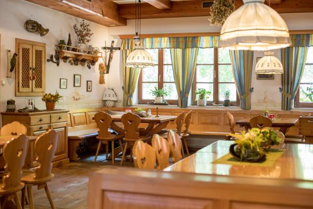 Ein traditionell eingerichtetes Restaurant mit Holztischen und Stühlen mit Herzmotiven.