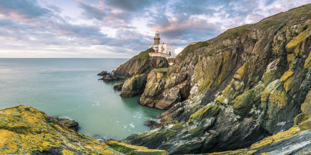 Der Leuchtturm von Howth Head steht auf einer Klippe am Meer.