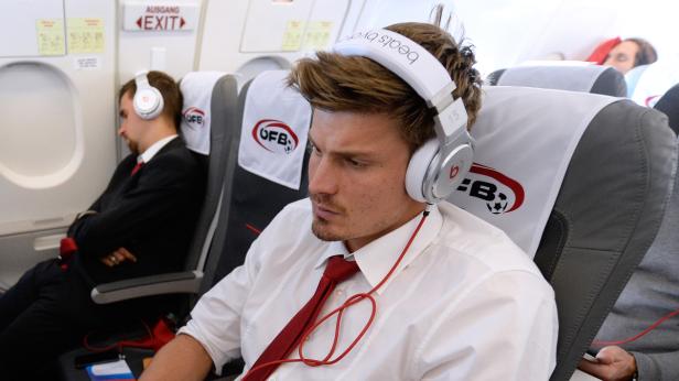Ein Mann mit Kopfhörern sitzt in einem Flugzeug.