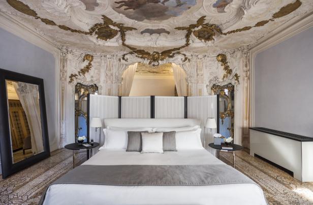 Ein luxuriöses Schlafzimmer mit Stuckdecke und einem großen Doppelbett.