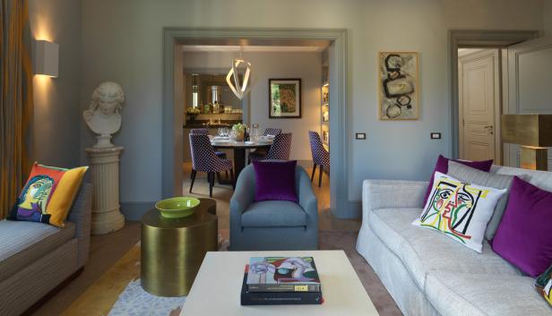 Ein Wohnzimmer mit Kunstwerken, darunter Kissen mit Picasso-Motiven und eine Büste.