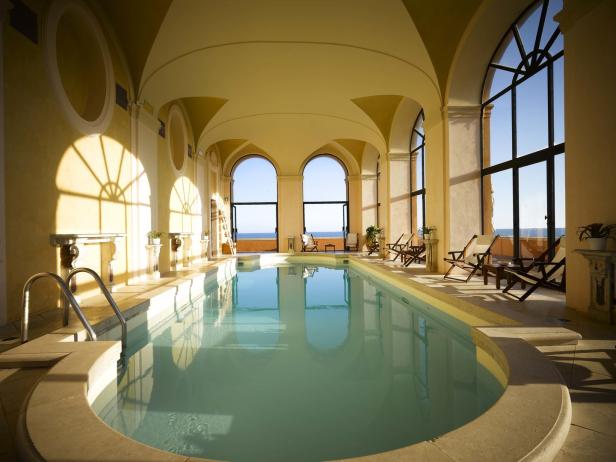 Ein Innenpool mit Liegestühlen und Blick auf das Meer.