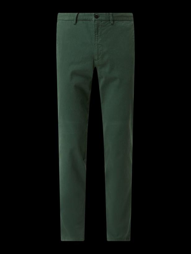 Eine grüne Stoffhose vor einem schwarzen Hintergrund.