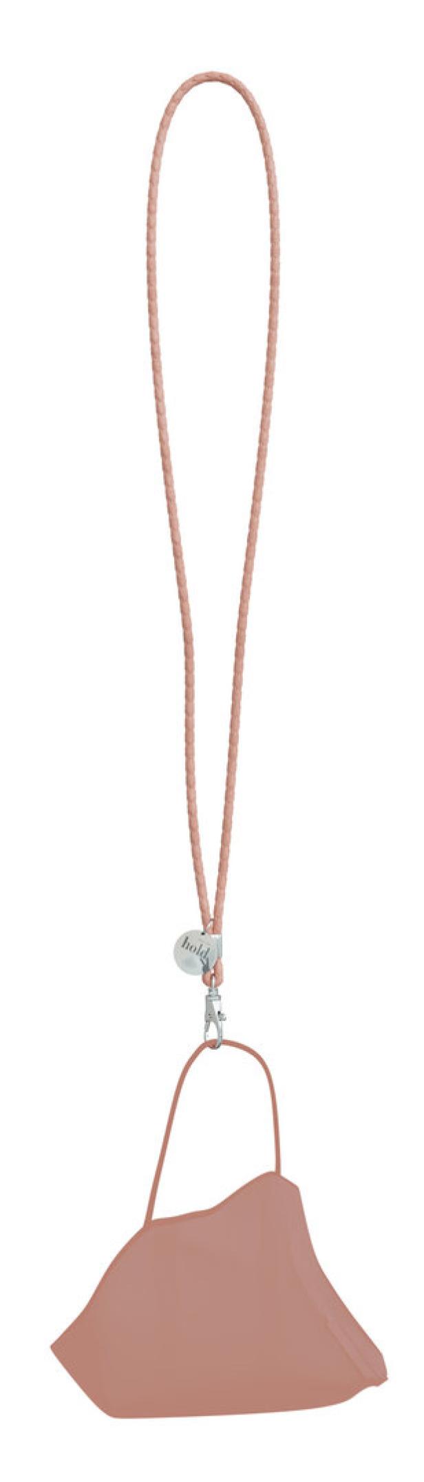 Eine rosa Maske hängt an einem geflochtenen Band mit einem silbernen Karabinerhaken.