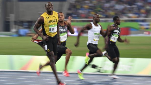 Usain Bolt führt ein Rennen auf einer blauen Laufbahn an.