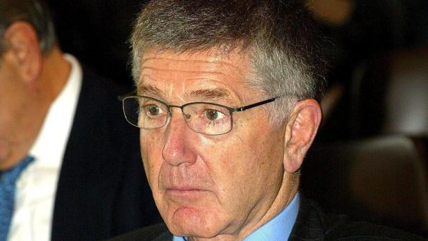 Ein Mann mit Brille und hellgrauen Haaren blickt nach links.