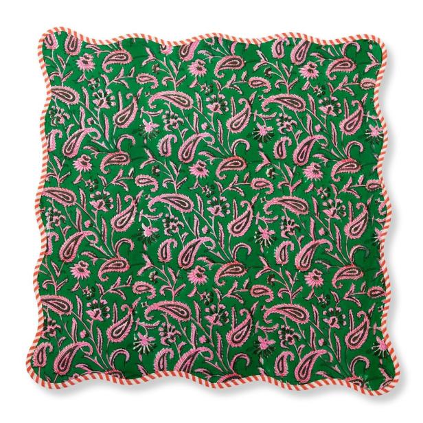 Ein grünes Kissen mit einem rosa Paisley-Muster und einem rot-weiß gestreiften Rand.