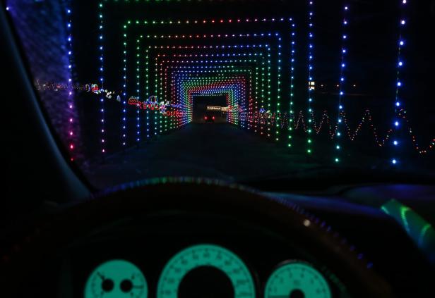 Blick aus dem Auto auf einen Tunnel aus bunten Lichtern.