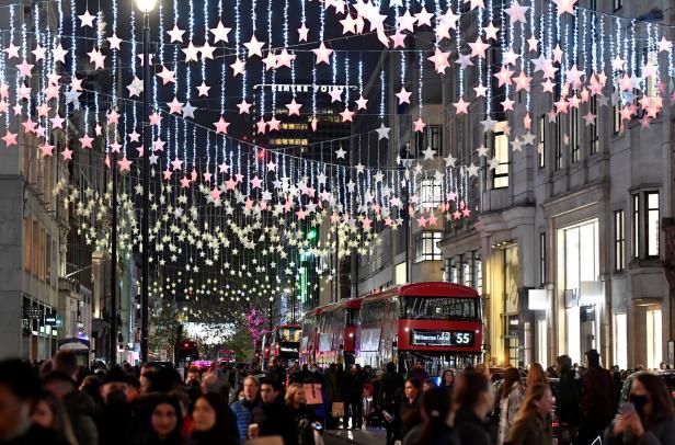 Eine belebte Straße in London ist mit Sternenlichtern geschmückt.
